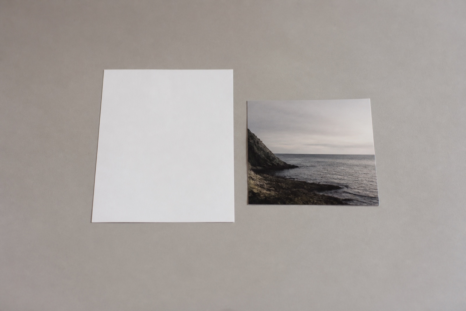 A blank sheet of paper and a single printed photo on an otherwise empty desk